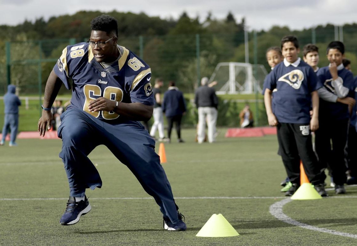 Los Angeles Rams guard Jamon Brown takes part in a drill during an NFL community event for schoolchildren at Surrey Sports Park in Guildford, England, Tuesday, Oct. 18, 2016. The Los Angeles Rams are due to play the New York Jets at Twickenham stadium in London on Sunday in a regular season NFL game. (AP Photo/Matt Dunham)